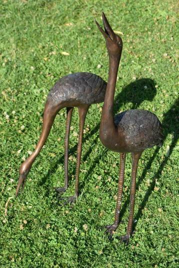 Beelden van een paar bronzen kraanvogels die waterstraal mak