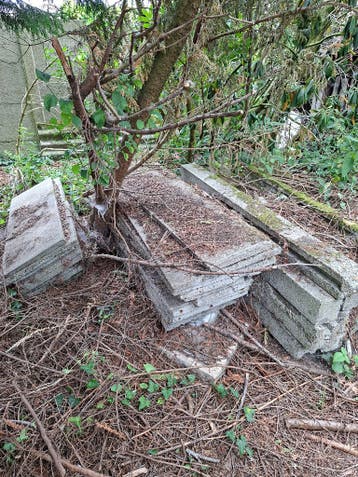 Oude betonplaten en -palen voor schutting