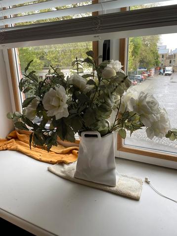 Vaas met witte kunstbloemen 