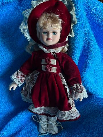 Porseleinen pop met rood kleed