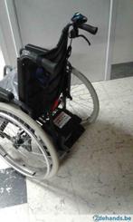 Manuele rolstoel met afneembare hulpmotor.
