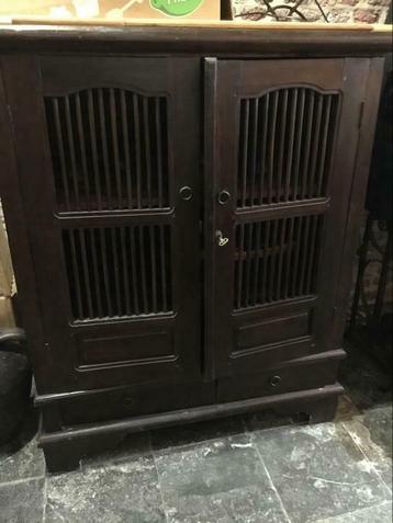 Meuble en bois exotique foncé avec doubles portes à barreaux