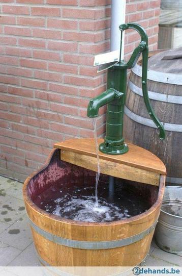 Waterpartij van eiken wijnvat met gietijzeren pomp, handpomp beschikbaar voor biedingen