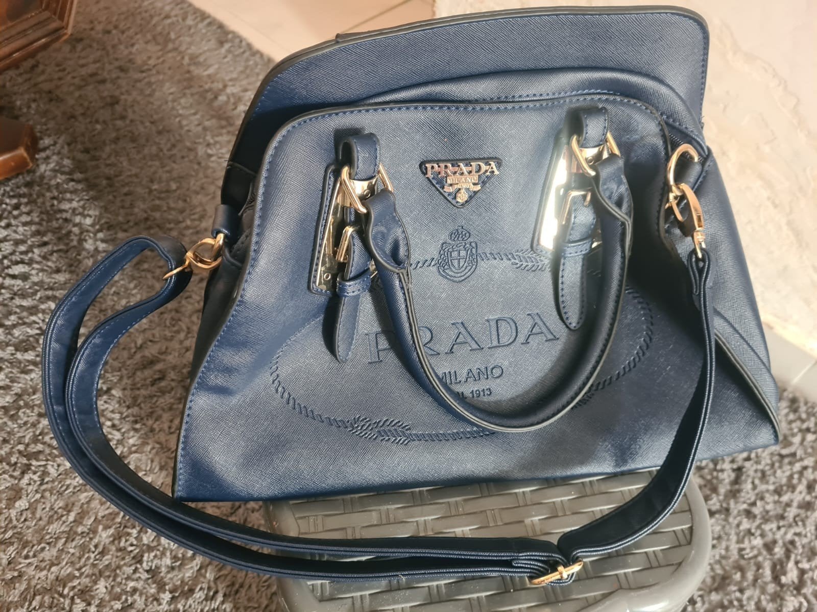 Prada schoudertas, Ophalen
