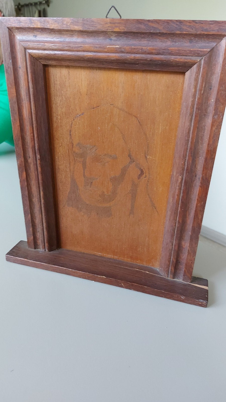 portret in houten paneel verwerkt (pyrografie), Ophalen