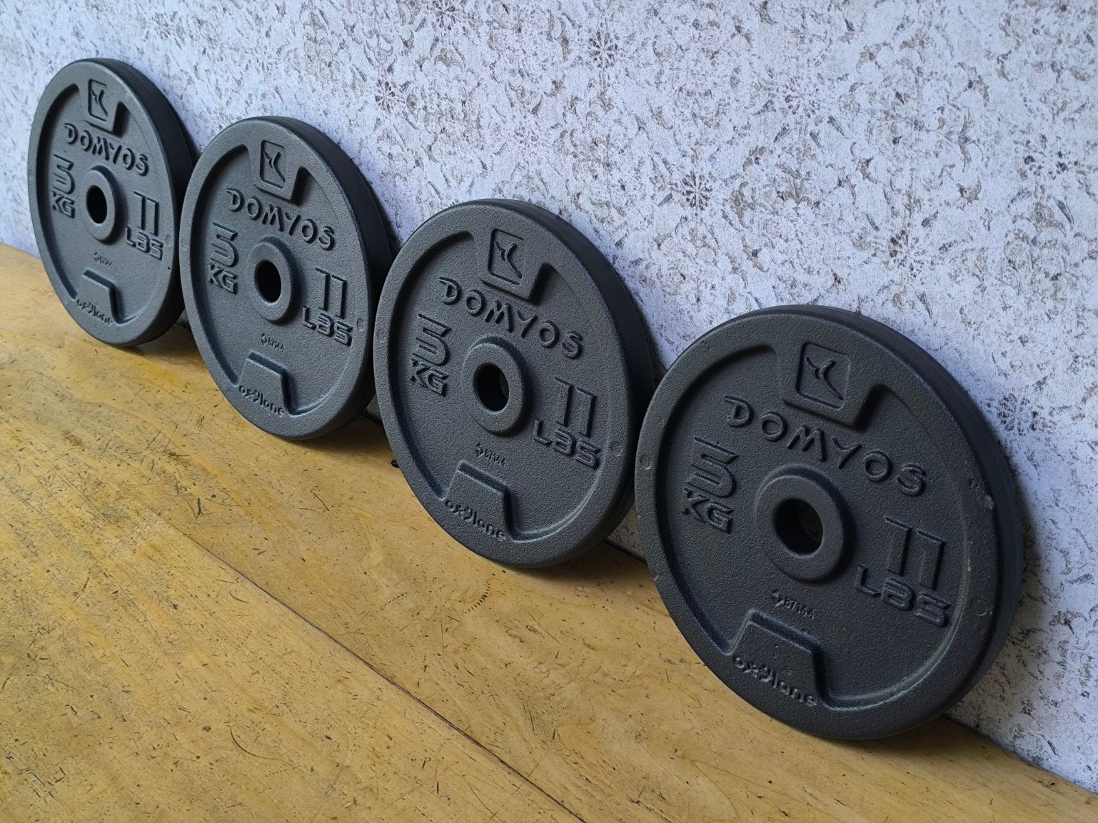 4 x Domyos 5kg plaques de musculation. 2,8cm., Enlèvement, Comme neuf, Bras, Plaques d'haltères