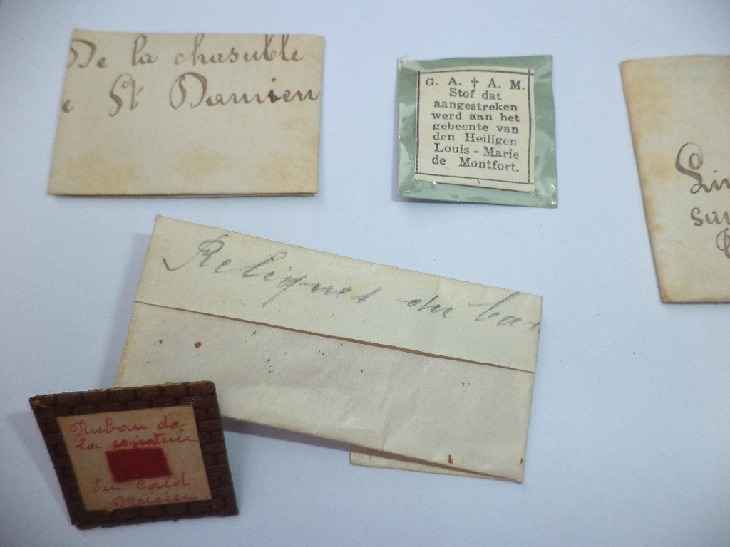 8x reliek relikwie o. a. Pater Damiaan Louis de Montfort, Antiek en Kunst, Ophalen of Verzenden