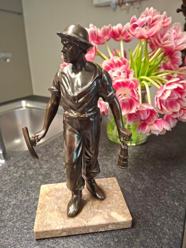 bronzen mijnwerker op marmer, Ophalen