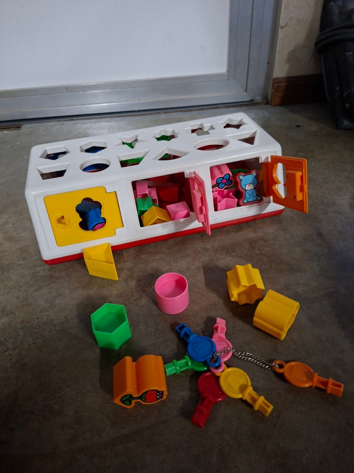 puzzel box met gekleurde figuurtjes en sleutel voor deurtje, Ophalen