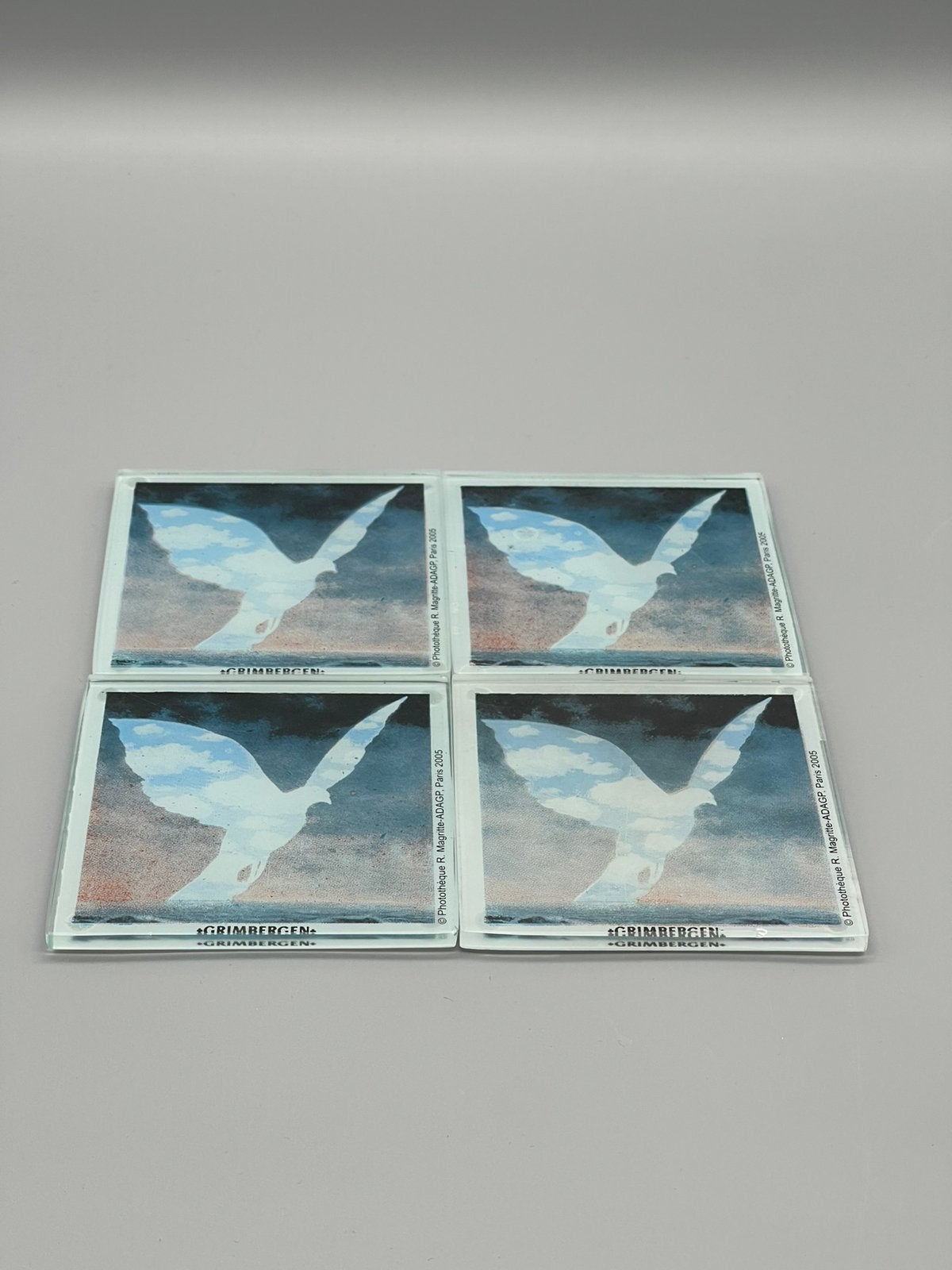 4 glazen onderzetters Grimbergen – René Magritte (2005), Gebruikt, Glasonderzetter, Stapelbaar, Meerkleurig