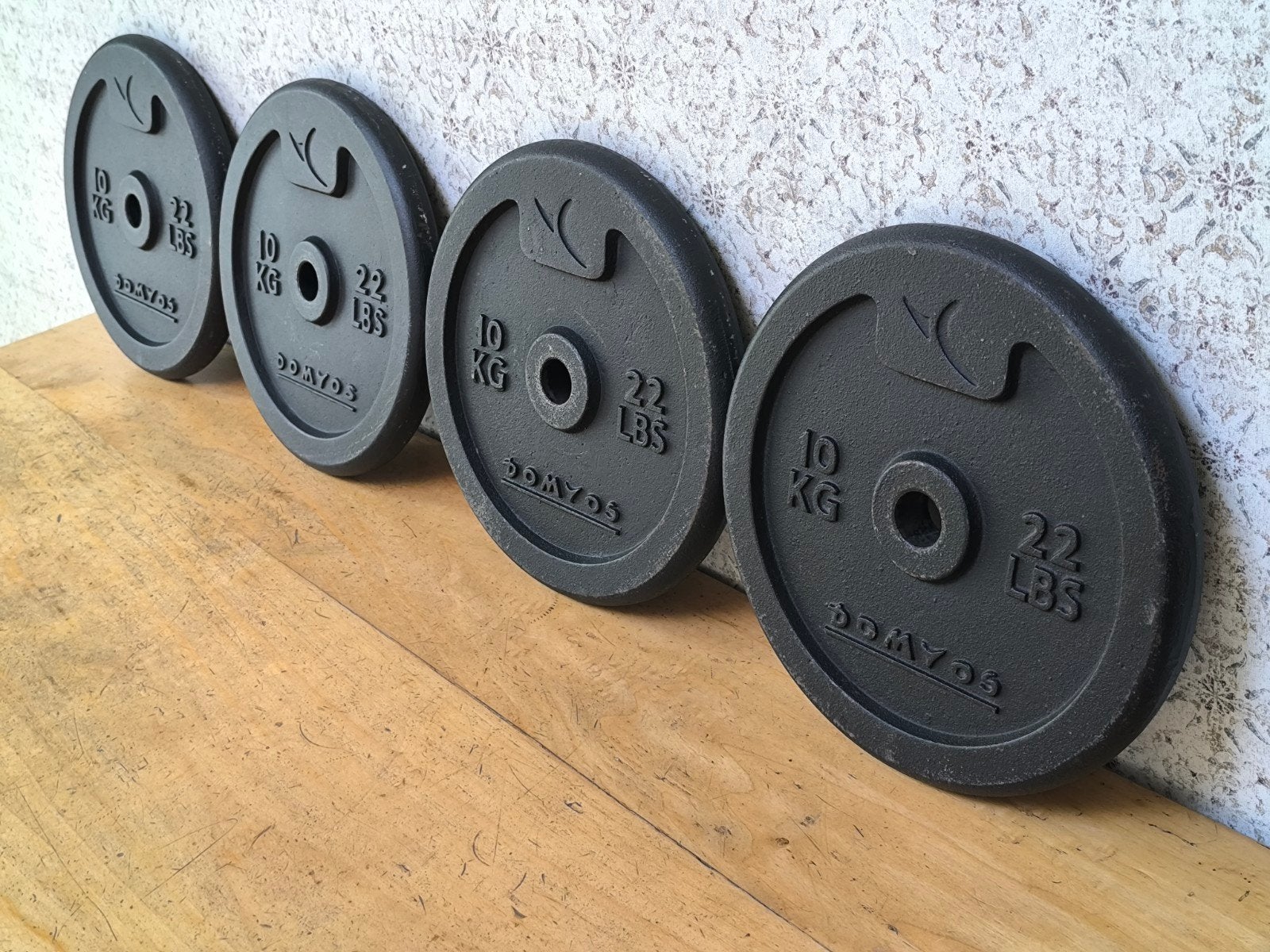 4 x Domyos 10kg plaques de musculation. 2,8cm., Enlèvement, Utilisé, Bras, Plaques d'haltères