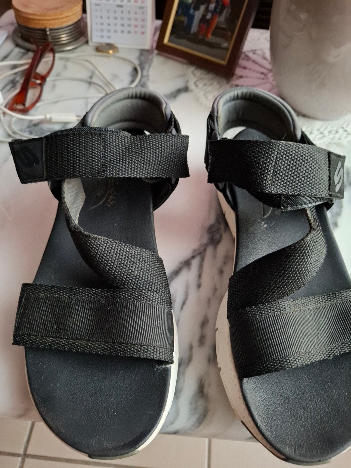 Sandalen van Sketchers, Ophalen