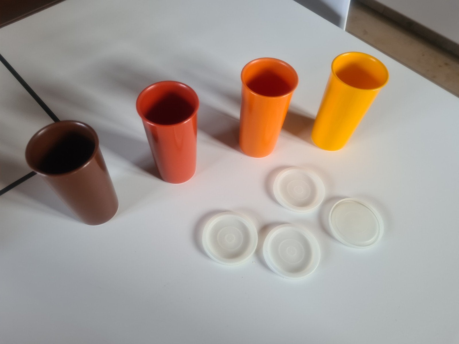 Gekleurde plastic potjes met dekseltje, Enlèvement