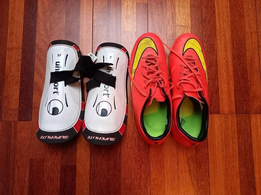 Rood/oranje voetbalschoenen Nike en beenbeschermers, Sports & Fitness, Enlèvement, Chaussures, Utilisé, Taille L