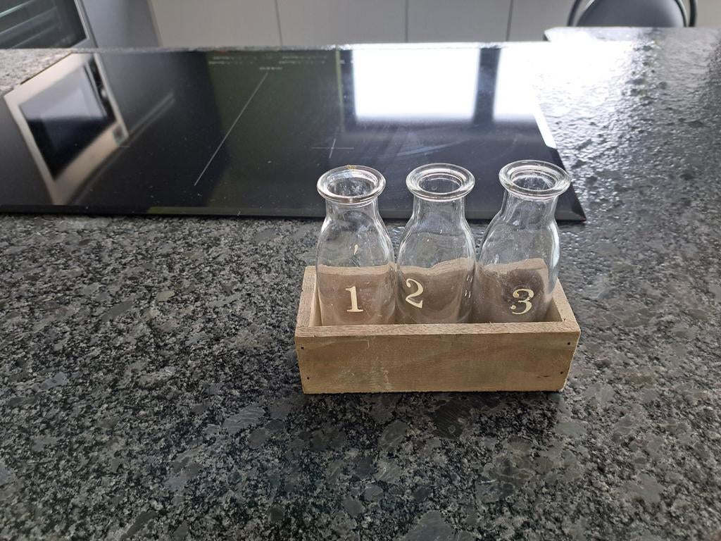 Kleine vaasjes in houten kader, Ophalen