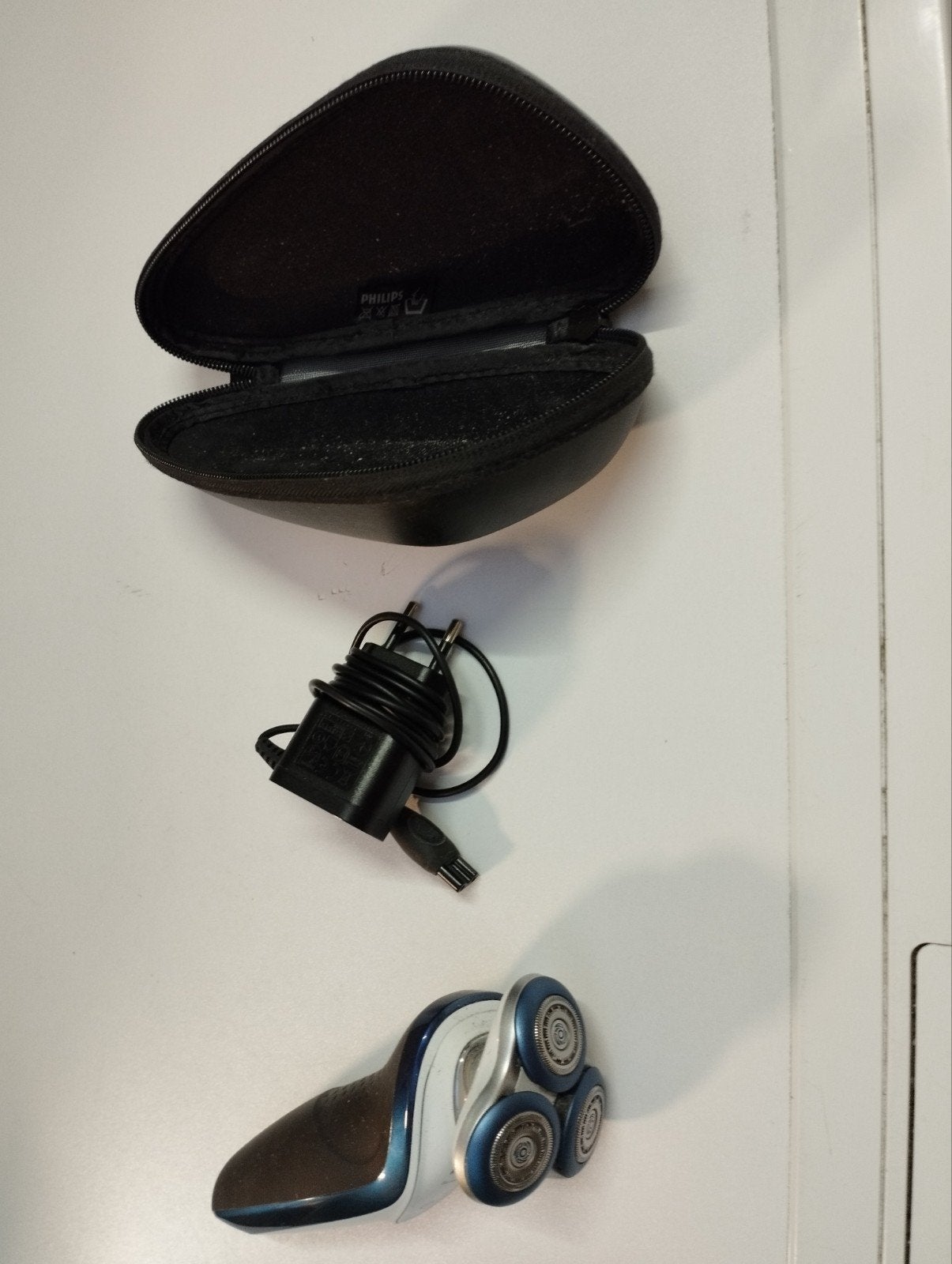 een scheerapparaat met lader en doos om erin te steken kleu, Ophalen