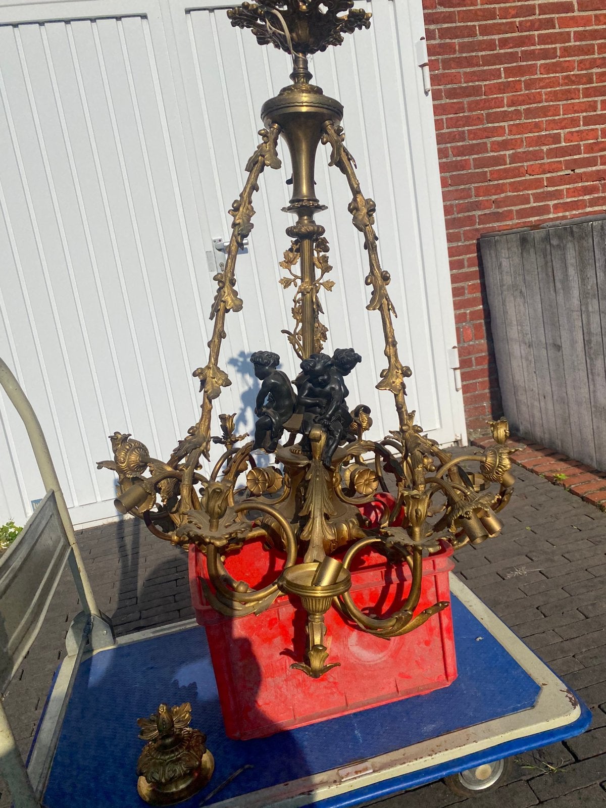Bronzen luster met drie engelen, Ophalen