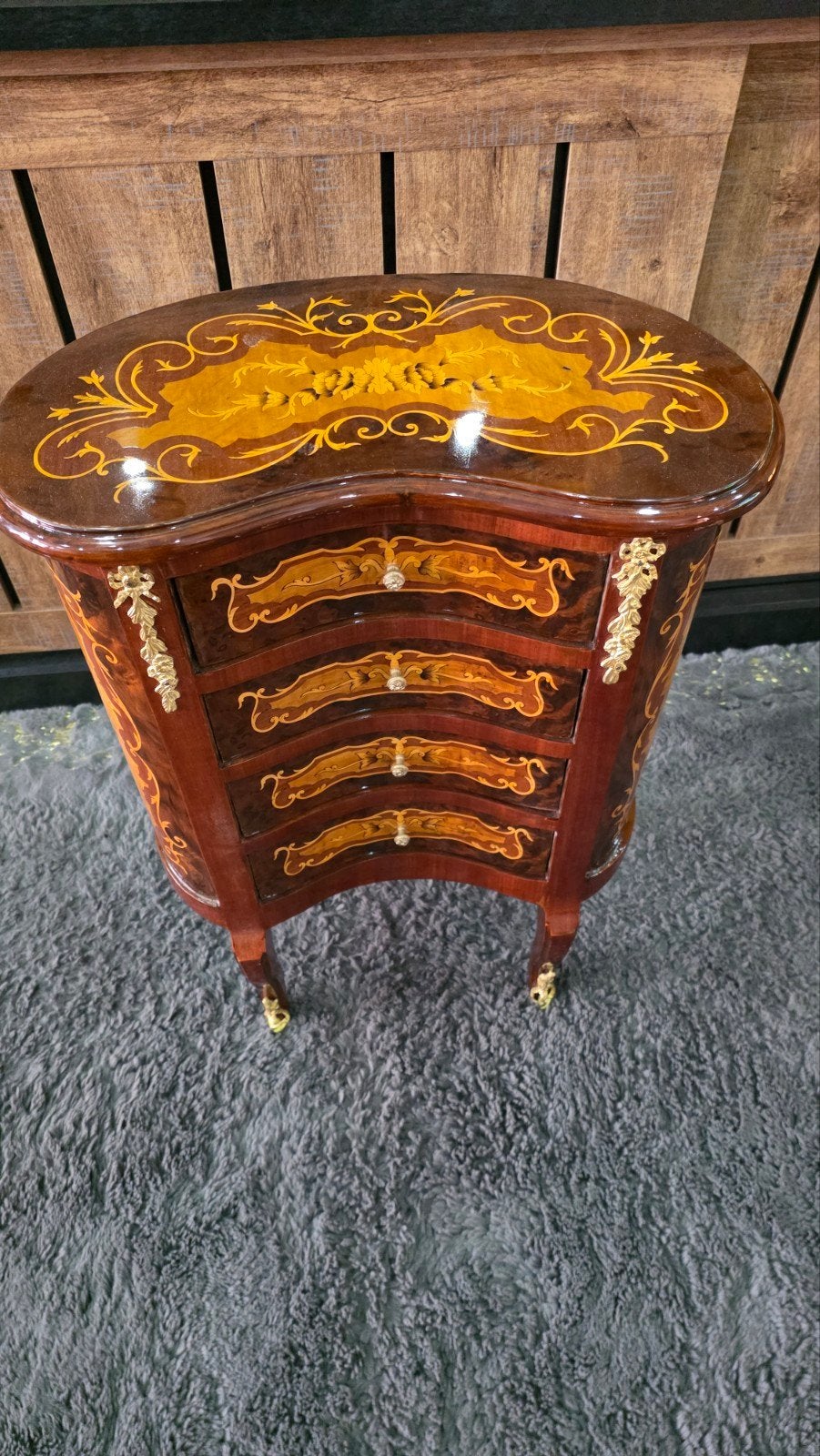 Het meubelstuk is uitgevoerd in een Louis XV-stijl met brons, Enlèvement