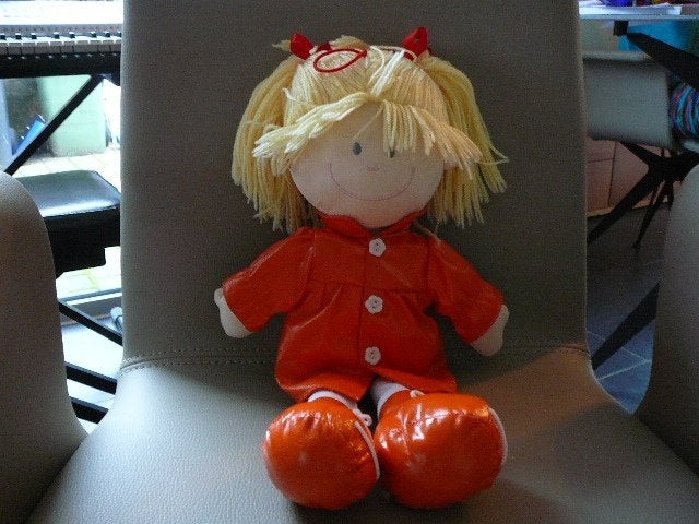Een pop met een oranje jas met blond haar, Ophalen of Verzenden, Gebruikt, Overige typen
