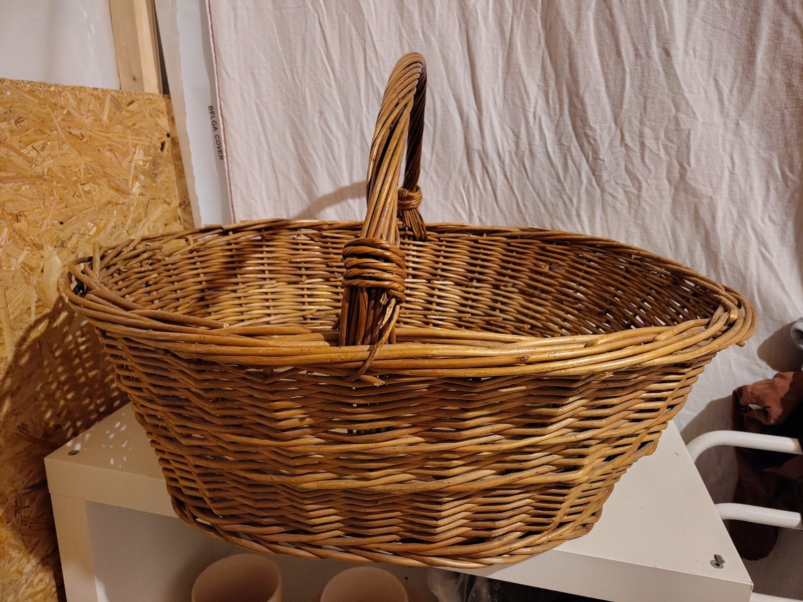 Grote gevlochten mand met houten bodem, Ophalen