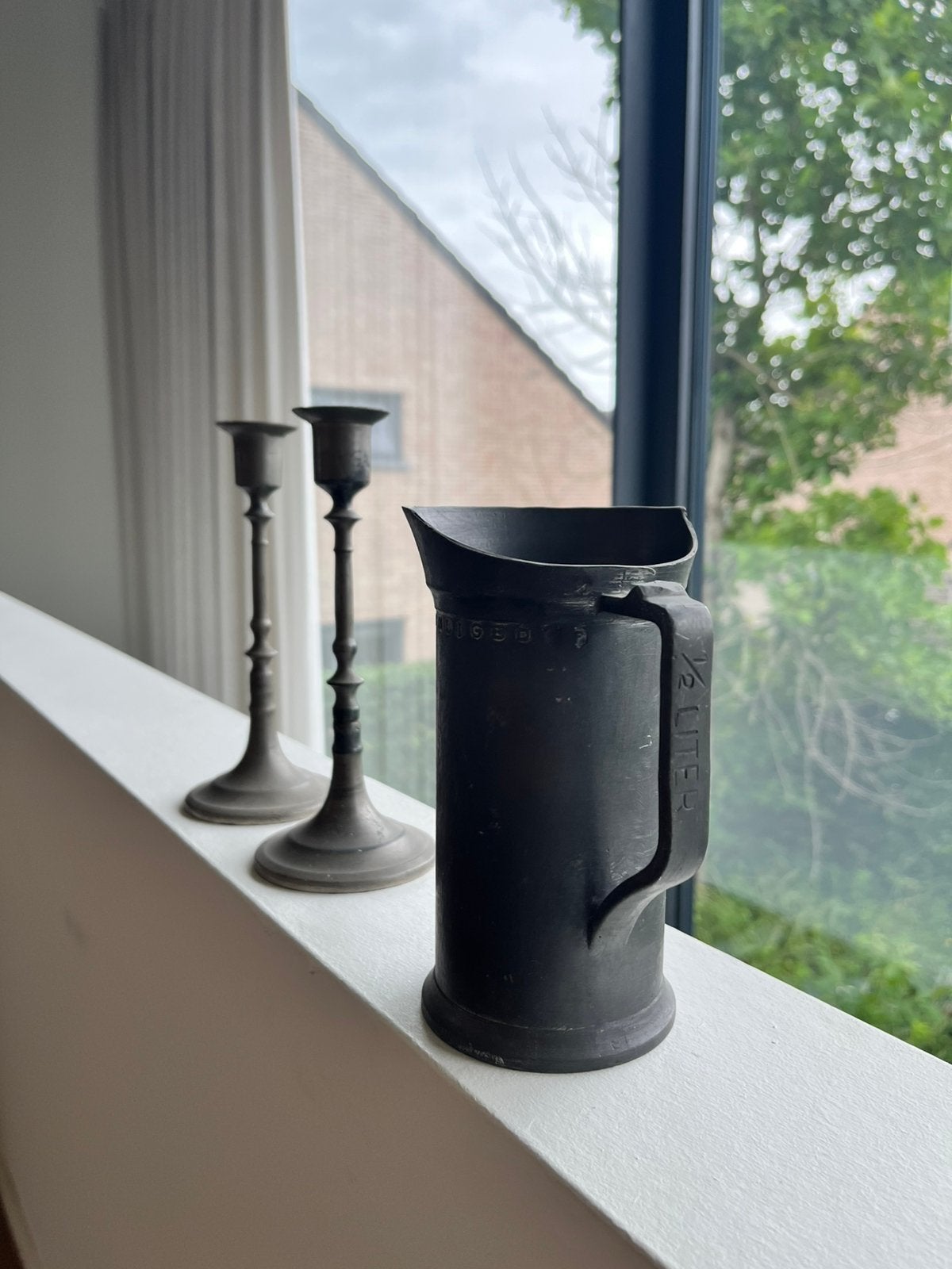 Tinnen kandelaars en beker, Ophalen