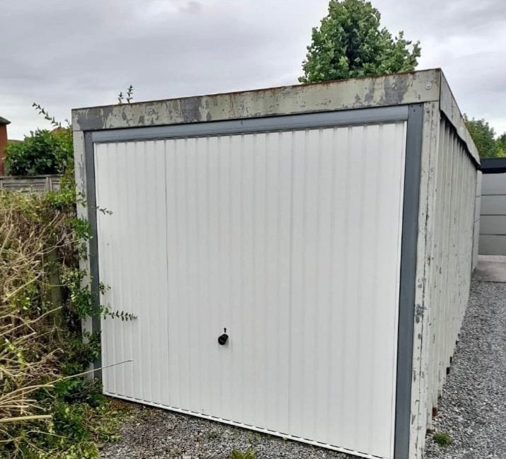 Garage en acier avec porte d'entrée blanche