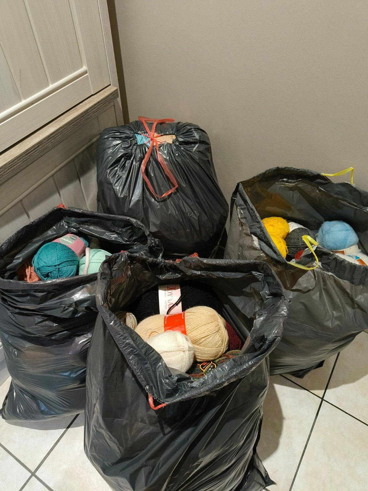 4 volle vuilzakken vol met breigaren, Ophalen