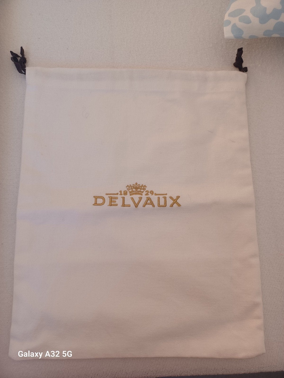 DELVAUX Housse pour sac brodée doré siglé, Envoi