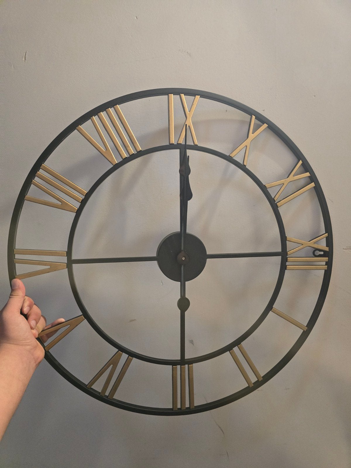 Grote wandklok van zwart en goud metaal - Romeinse cijfers, Ophalen of Verzenden