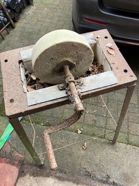 oude slijpsteen in een bak, Ophalen