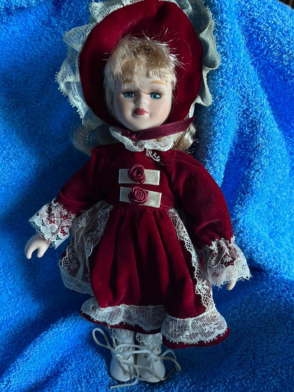 Poupée en porcelaine avec tissu rouge foncé, Envoi, Comme neuf