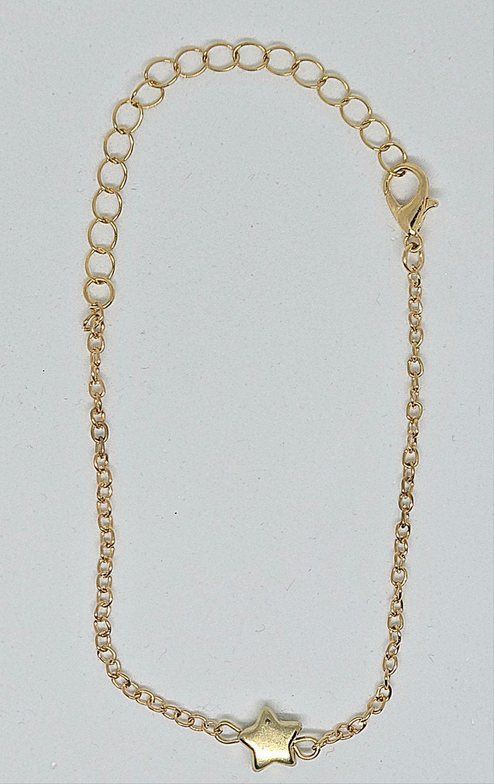 Ongedragen Goudkleurige Schakelarmband met Ster Bedel, Nieuw, Ophalen of Verzenden, Met bedels of kralen, Goud
