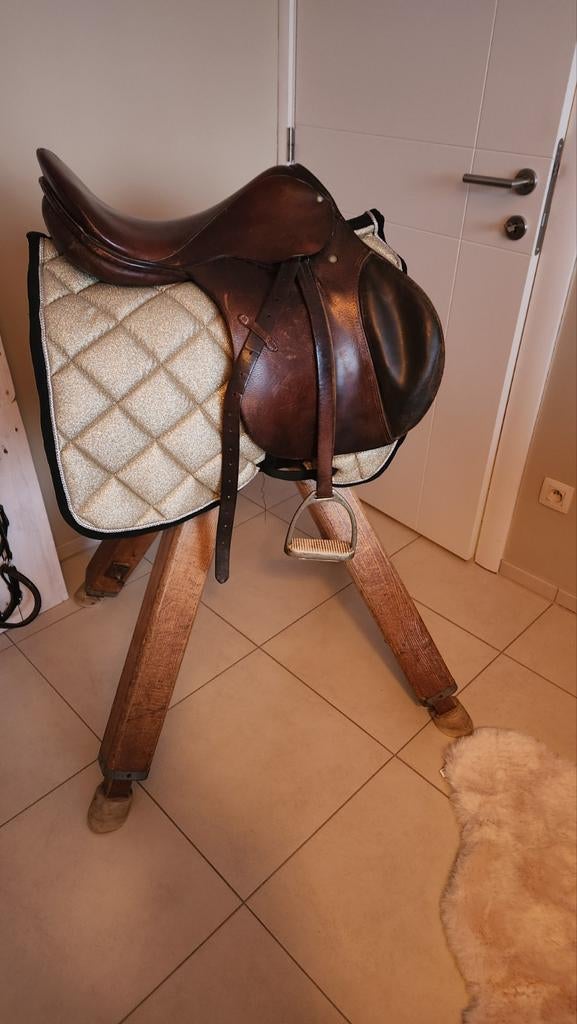 Oude turnbok met paardenzadel en houten bord met halsters, Ophalen
