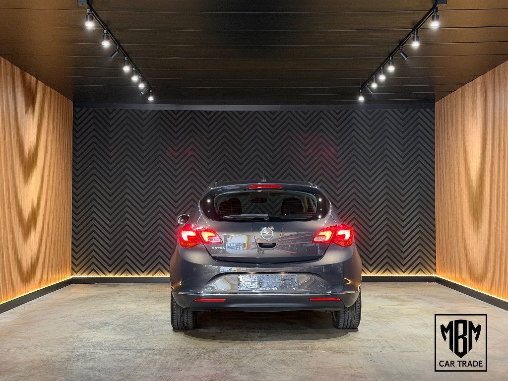 ✅ Opel Astra 1.6i GARANTIE Airco Cruise C Parksensoren V+A, Voorwielaandrijving, Euro 5, Stof, Zwart