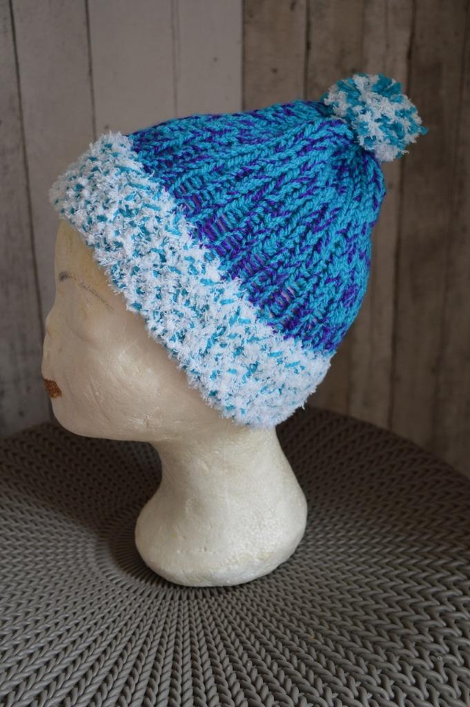 Handgebreide muts groenblauw, witte boord en pompom om 48 cm, Handgemaakt, Ophalen of Verzenden, Nieuw, Muts