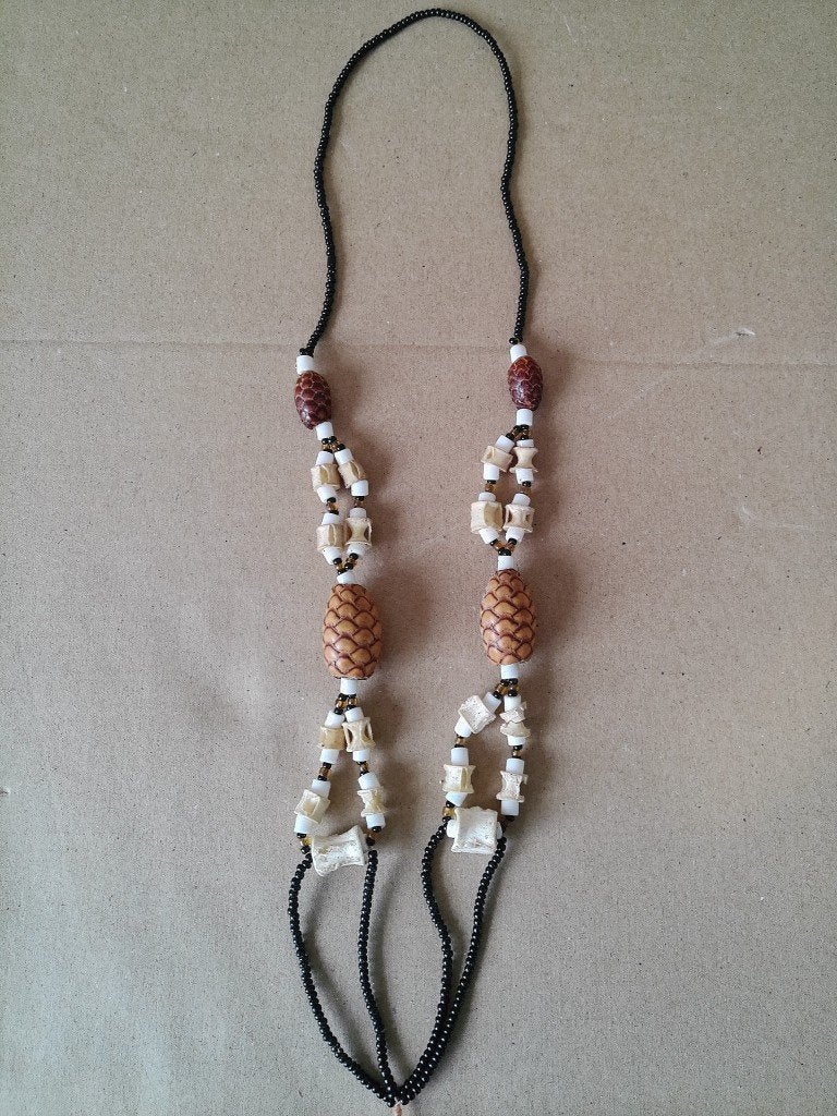 Afrikaanse amulet ketting dennenappels en bot of schelp 34cm, Antiek en Kunst, Sieraad, Natuurlijk materiaal, Afrika, Handgemaakt