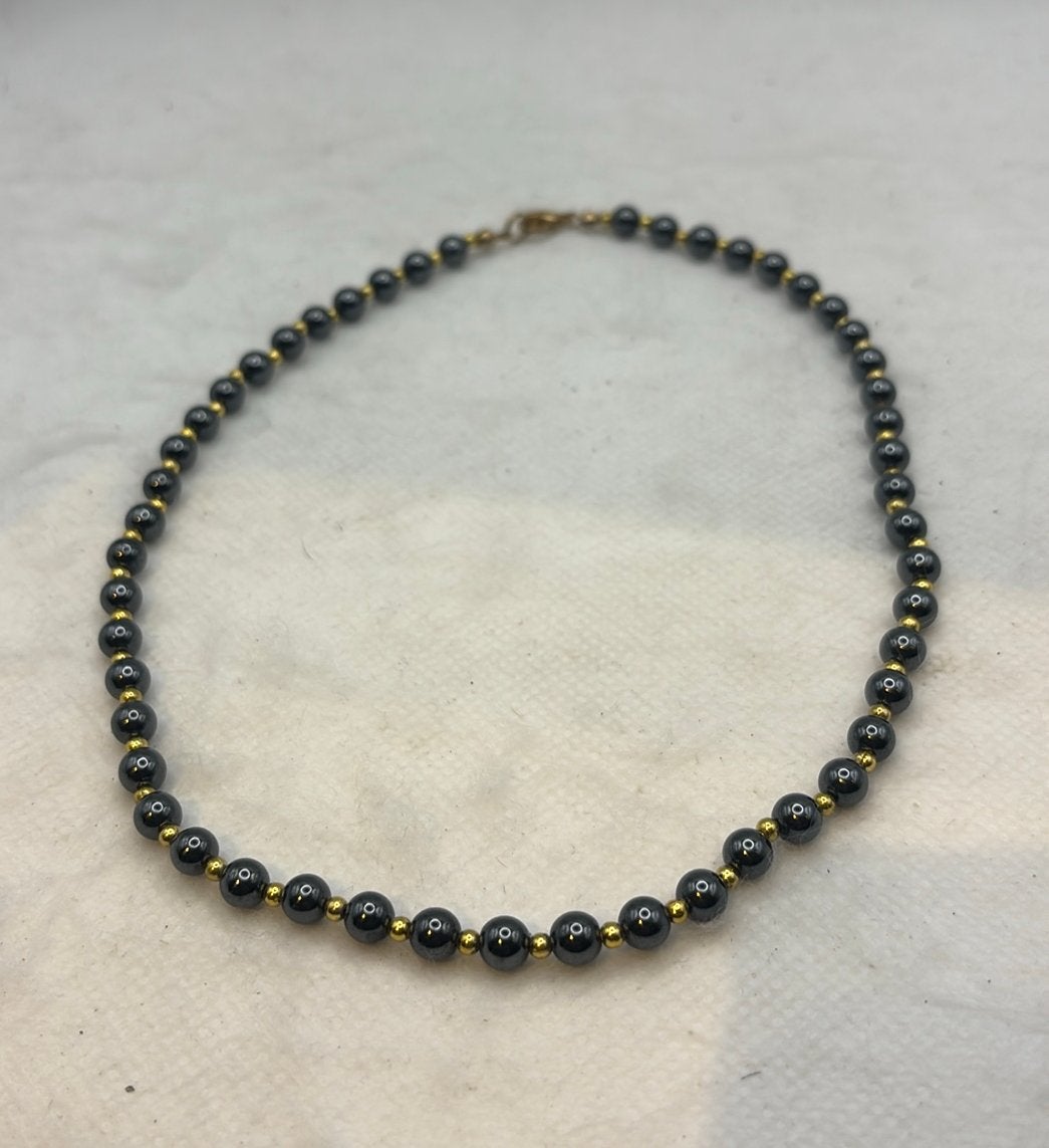 Donkergrijze kralenketting met goudkleurige spacers - 14cm, Ophalen of Verzenden, Gebruikt, Goud
