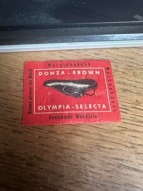 étiquette de boîte d'allumettes Donza marron Olympia selecta, Info@selcabr.lb, Boîtes ou marques d'allumettes, Enlèvement ou Envoi