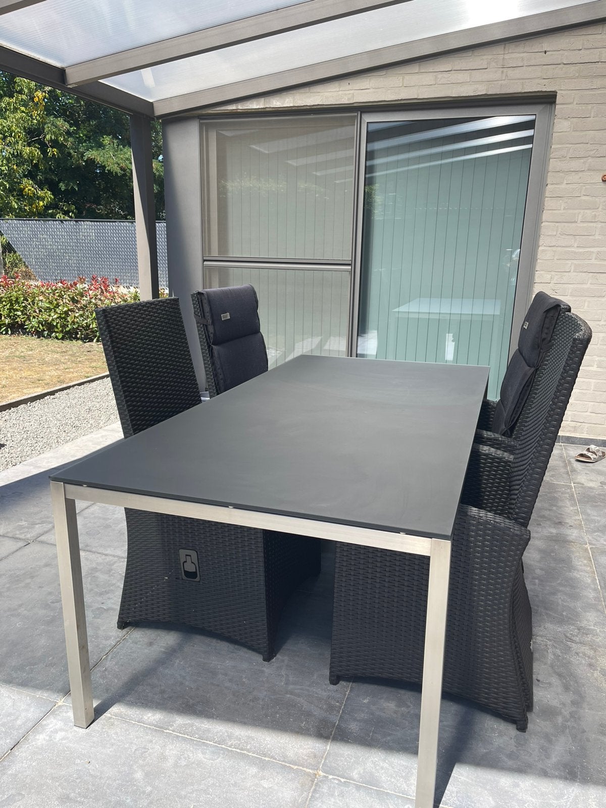Tuintafel met mat zwart glazen blad en 4 stoelen, Tuin en Terras, Ophalen, Inox, 6 zitplaatsen, Zo goed als nieuw
