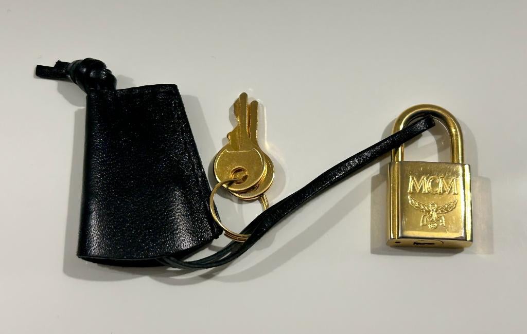 MCM goudkleurig slot in zwarte hoes, Handtassen en Accessoires, Tassen | Damestassen, Ophalen of Verzenden, Nieuw, Overige kleuren