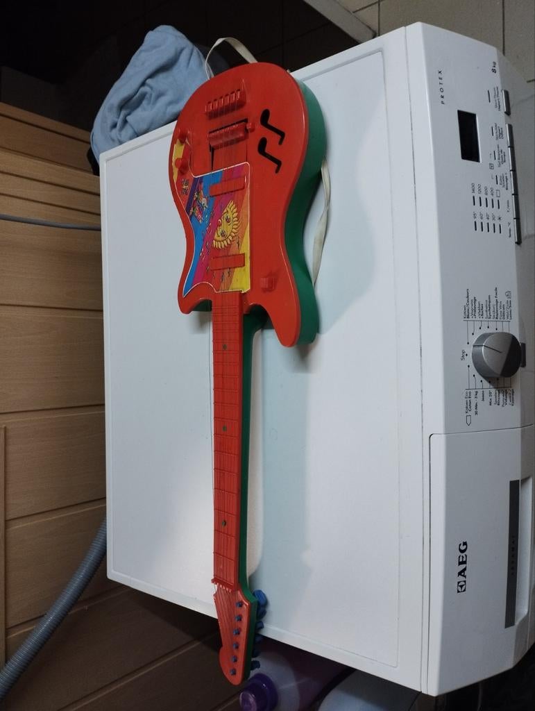 Een speelgoed kinder gitaar kleur rood, Enlèvement