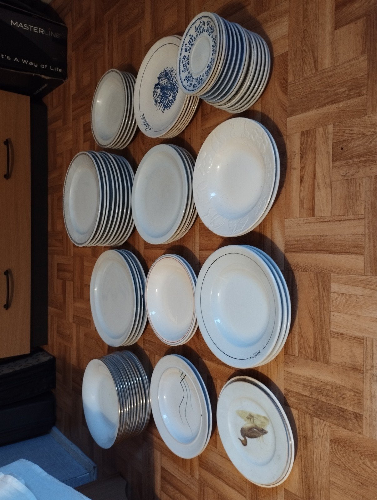 Een massa borden kleur wit sommige met tekeningen erop kleur, Enlèvement