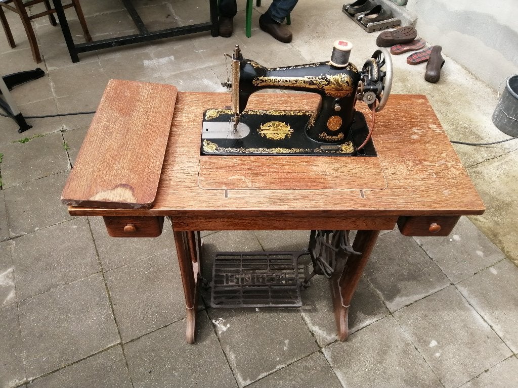 Oude Singer naaimachine in houten tafel, Ophalen