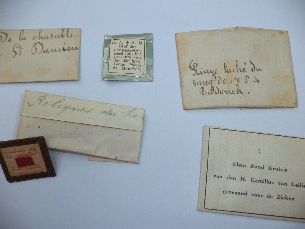 8x reliek relikwie o. a. Pater Damiaan Louis de Montfort, Antiek en Kunst, Ophalen of Verzenden