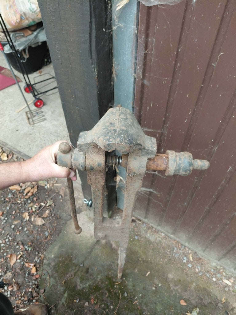ancien étau en fer a enfoncé dans la terre, Ophalen