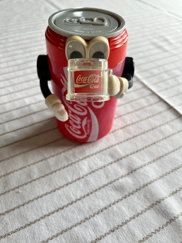 Coca Cola spaarpot voor munten met beweegbare arm 14 cm hoog, Verzamelen, Spaarpotten, Ophalen, Gebruikt, Kunststof, Object of Gebouw