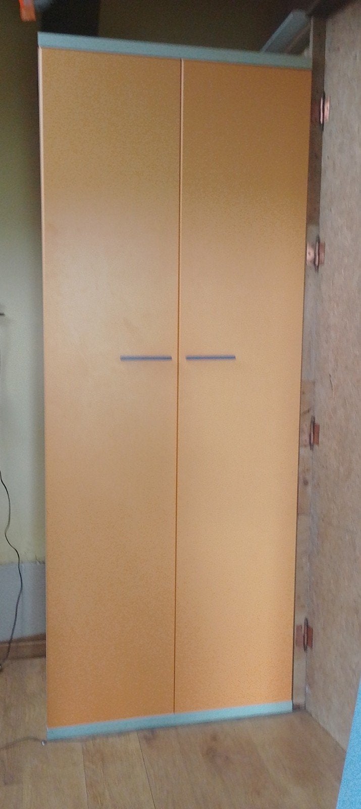 Hoge oranje kleerkast., Ophalen