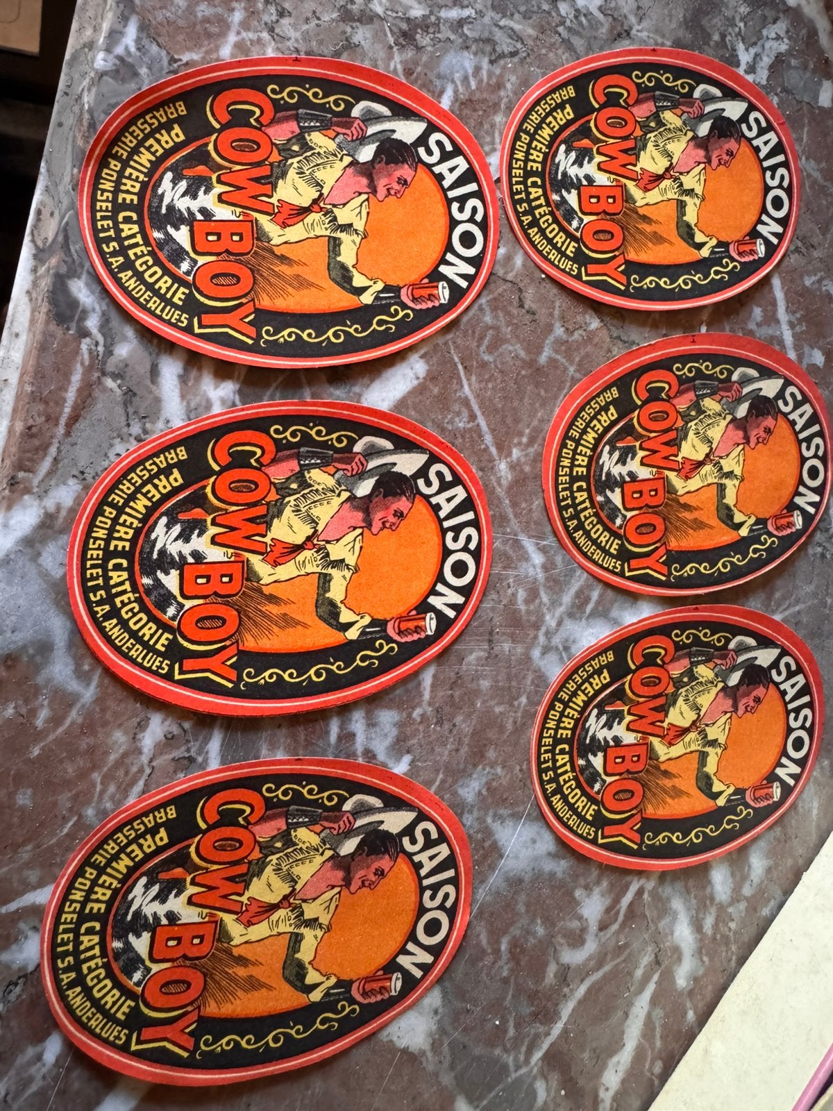 Lot de 6 etiquettes publicitaires Saison Cowboy – Anderlues, Maison & Meubles, Enlèvement ou Envoi, Comme neuf, Orange