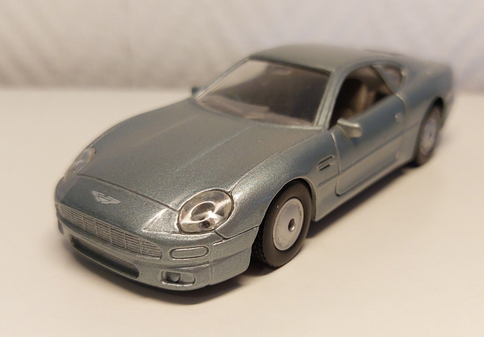 ASTON MARTIN DB 7 argent. Casque Maisto 1/40., Enlèvement ou Envoi, Comme neuf, Voiture, Autres marques