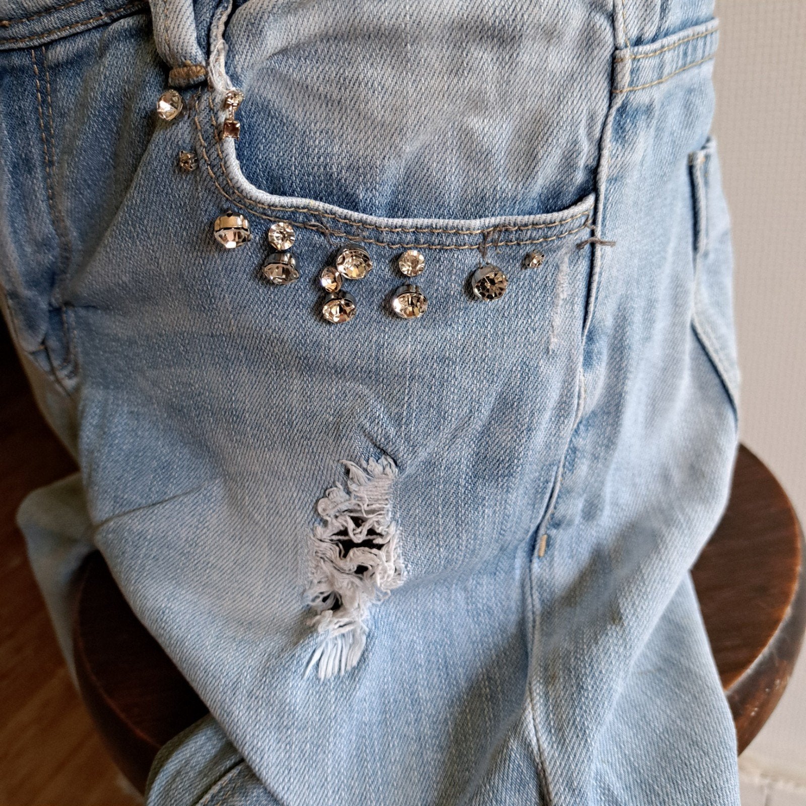 Jeansbroek met scheuren en parels, Ophalen